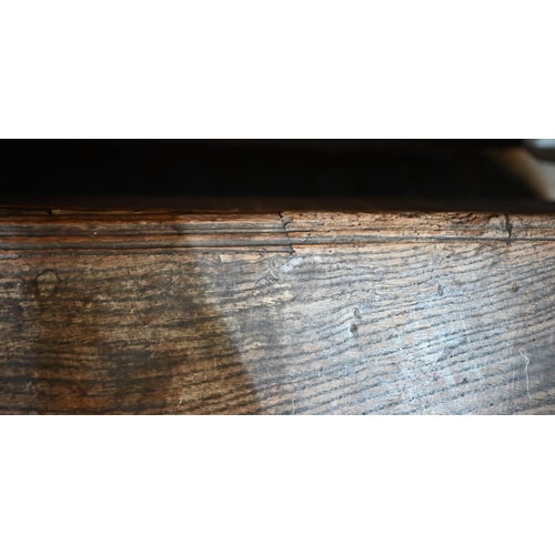 939 - A 17th century oak six plank coffer, with iron staple lock and key, the relief carved front centred ... 