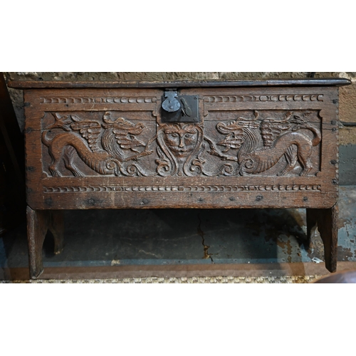 939 - A 17th century oak six plank coffer, with iron staple lock and key, the relief carved front centred ... 