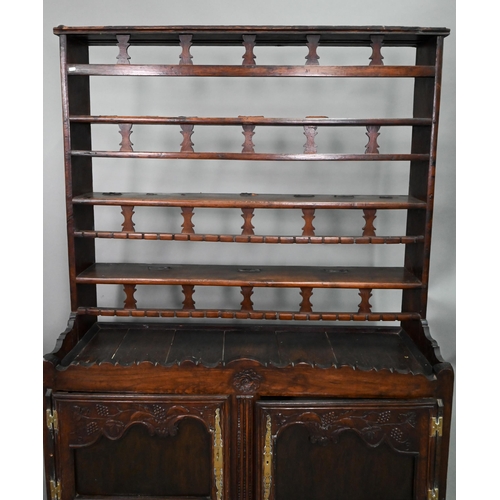 11 - An antique provincial French oak high dresser, the three tier rack with pierced balustrades, over tw... 
