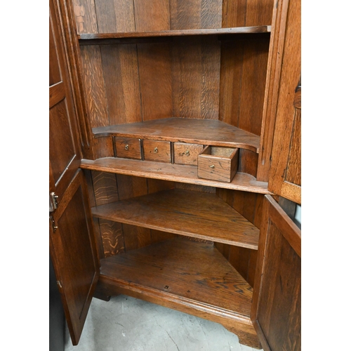 23 - A Georgian style oak floor standing corner cabinet (one piece) with panelled cupboard doors, standin... 