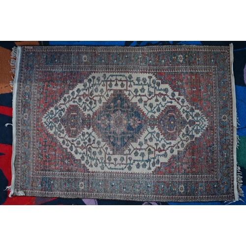 138 - An early 20th century Persian Bakhari rug, the navy triple medallion on cream gorund with red corner... 