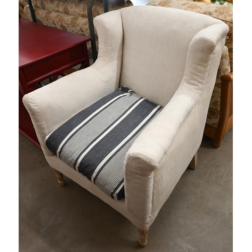 102 - A pair of calico wing-back armchairs (for re-upholstery) with blue and white striped fabric seat cus... 