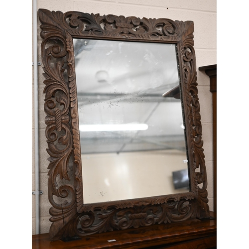 114 - A foliate carved and pierced hardwood framed 'Florentine' mirror, 90 x 114 cm