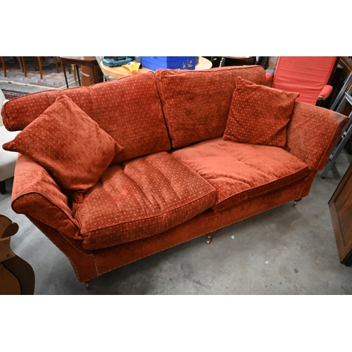 115 - A Duresta three seater sofa with patterned red fabric and three turned front supports with brass cas... 