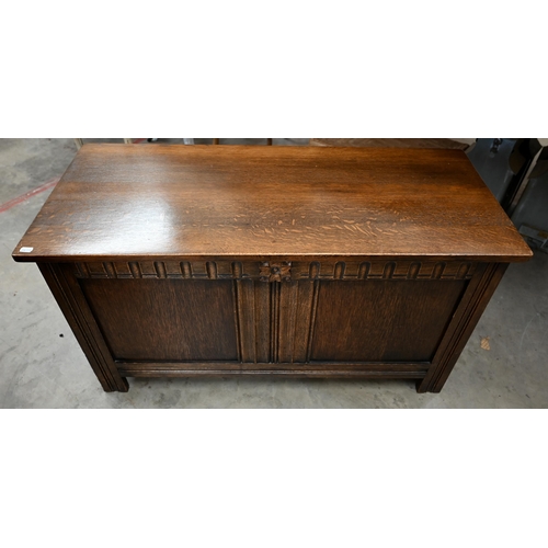 128 - A 20th century oak blanket chest/coffer, with a hinged top on panelled base with carved detail, 104 ... 