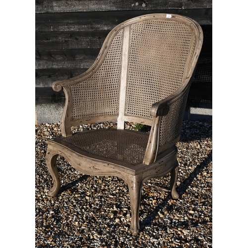 132 - A distress painted highbacked bergere armchair, double caned back and single caned seat