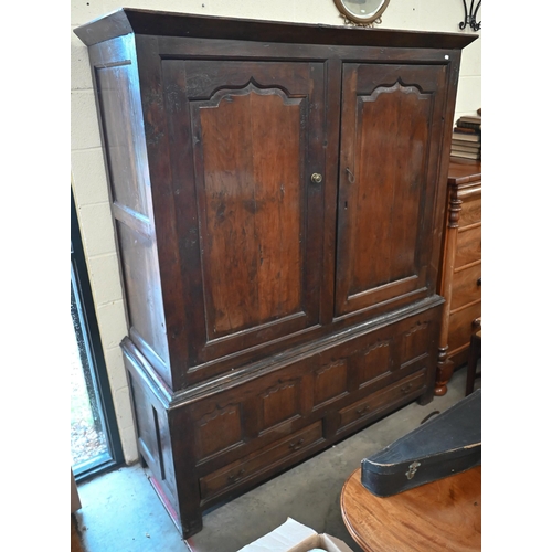 133 - An 18th century and later oak cupboard with panelled doors on two drawer base (2 sections, missing o... 