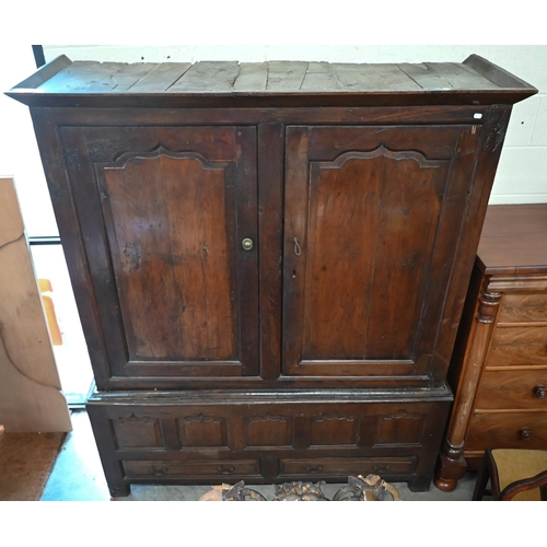 133 - An 18th century and later oak cupboard with panelled doors on two drawer base (2 sections, missing o... 