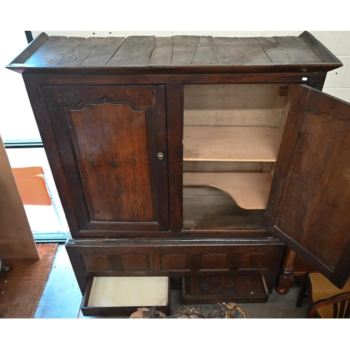 133 - An 18th century and later oak cupboard with panelled doors on two drawer base (2 sections, missing o... 