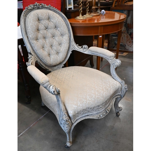 134 - An antique French carved and painted salon armchair in damask buttonback upholstery