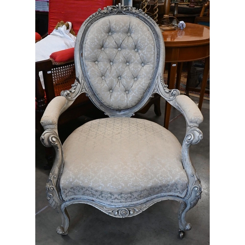 134 - An antique French carved and painted salon armchair in damask buttonback upholstery