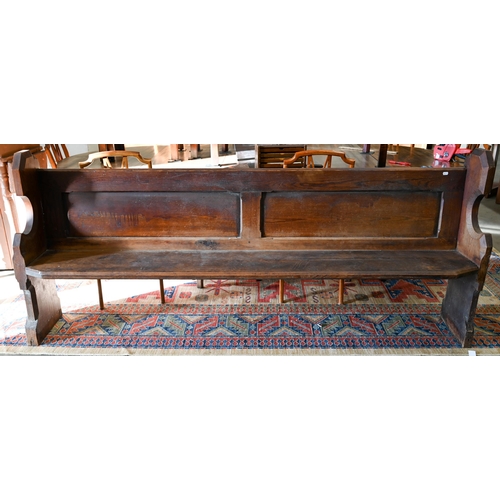 139 - An antique stained pine pew, 220 cm wide