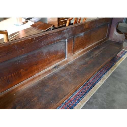 139 - An antique stained pine pew, 220 cm wide