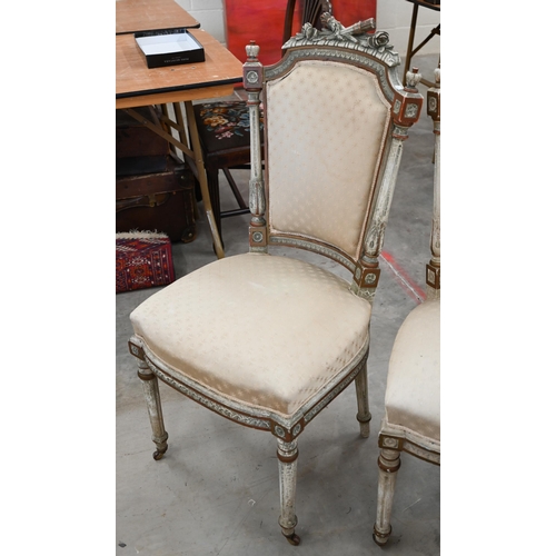 141 - A pair of painted and gilded carved French side chairs, on fluted front legs on casters