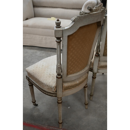 141 - A pair of painted and gilded carved French side chairs, on fluted front legs on casters