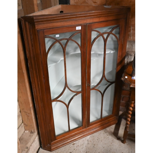 154 - A mid 19th century mahogany hanging corner cupboard with twin glazed doors and painted interior with... 