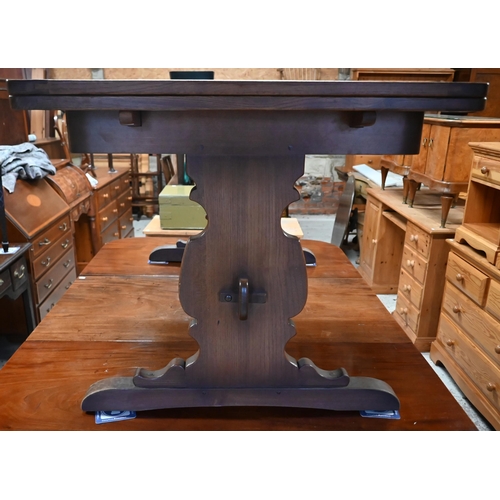 183 - An Ercol elm draw leaf dining table, on shaped trestle ends united by a mid-height centre stretcher,... 