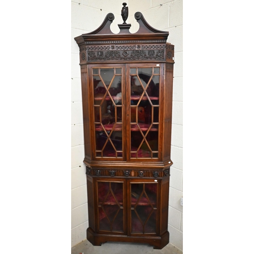 2 - A carved mahogany floor-standing corner cabinet in two parts, with astragal glazed doors and velvet ... 