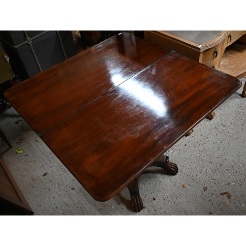 211 - A Victorian mahogany fold over tea table, raised on an acanthus carved support to a platform base, o... 