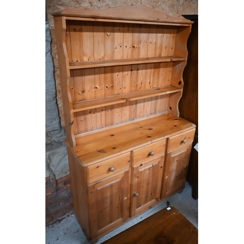 212 - A modern pine cottage dresser, with three drawers over cupboards, 121 cm x 41 cm x 185 cm h