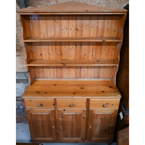 212 - A modern pine cottage dresser, with three drawers over cupboards, 121 cm x 41 cm x 185 cm h