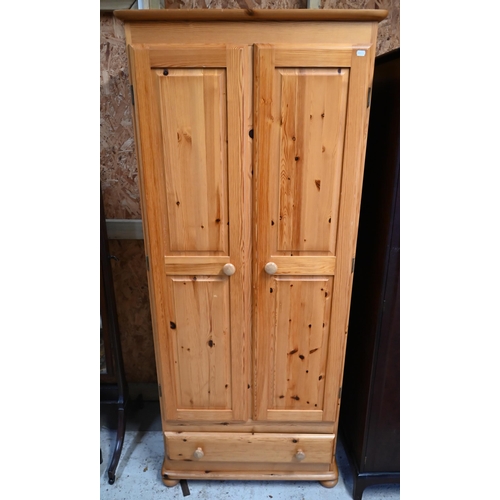 220 - A modern pine two door wardrobe, with drawer to base, raised on bun feet, 81 cm w x 53 cm x 188 cm h