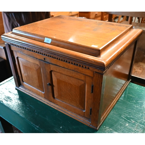 224 - An oak canteen cabinet, the hinged top over a pair of cabinet doors enclosing three graduated drawer... 