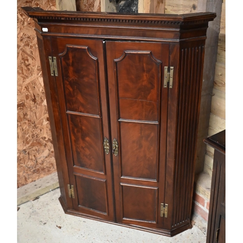 228 - A Georgian mahogany corner hanging cupboard, the dentil moulded cornice over panelled doors