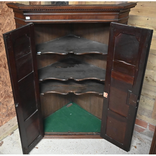 228 - A Georgian mahogany corner hanging cupboard, the dentil moulded cornice over panelled doors