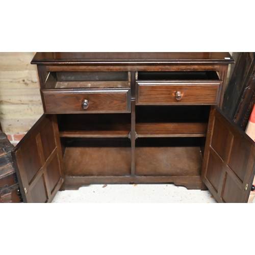 229 - An Ercol style cottage dresser, the domed open rack over two drawers and cupboards, 93 cm w x 40 cm ... 