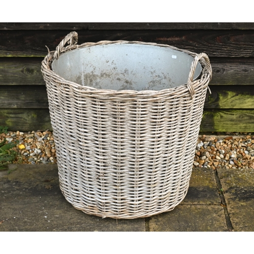 234 - A large contemporary wicker log basket, sacking lined and mounted to castors, 76 cm x 51 cm x 60 cm ... 