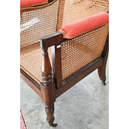 29 - A mid 19th century mahogany framed bergere library chair with baluster turned supports and brass cas... 