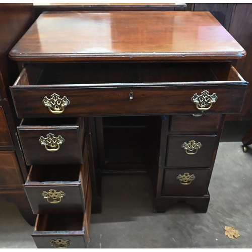 38 - A George III mahogany kneehole desk with seven drawers and secret frieze drawer over recessed centra... 