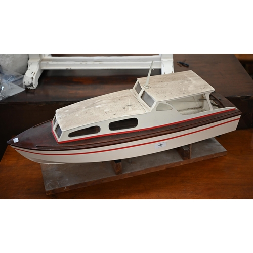 449 - # A painted wood model motor-yacht with electric motor, 75 cm long, on stand