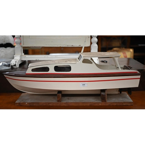 449 - # A painted wood model motor-yacht with electric motor, 75 cm long, on stand