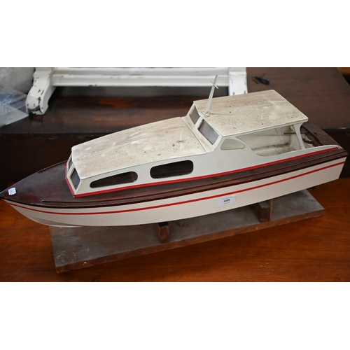 449 - # A painted wood model motor-yacht with electric motor, 75 cm long, on stand