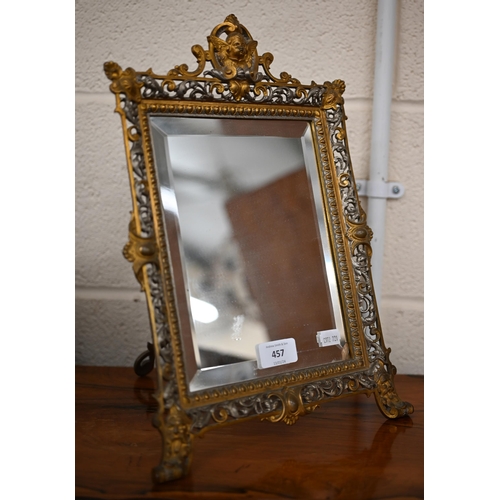 457 - A Continental gilt and silvered brass easel mirror with bevelled plate and ornate pierced frame surm... 