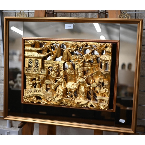 459 - A Chinese carved and gilded relief of noble ladies in a palace garden, in mirrored frame, 52 x 66 cm... 