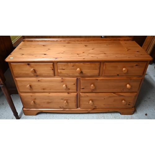 546 - A modern stained pine seven drawer chest with turned handles, 134 cm wide x 45 cm deep x 78 cm high