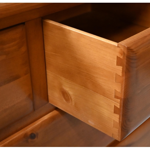 546 - A modern stained pine seven drawer chest with turned handles, 134 cm wide x 45 cm deep x 78 cm high