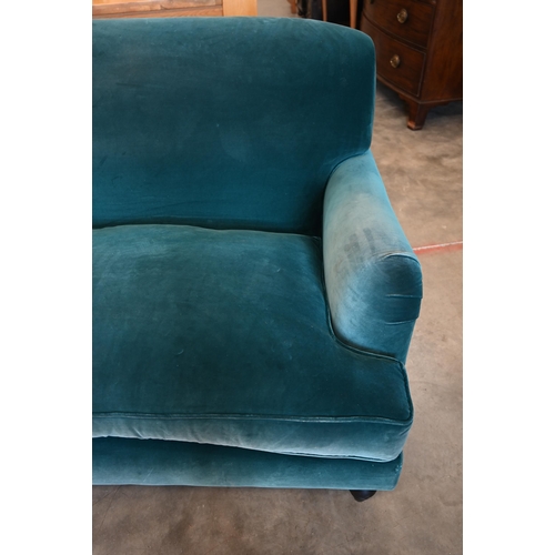 75 - A Howard stye love seat in peacock blue velour fabric, ebonised turned front supports, 140 x 100 x 9... 