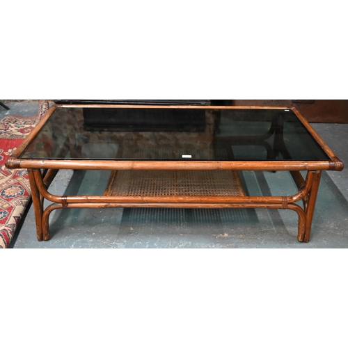 552 - A KOK (Maison) French bamboo and rattan coffee table, with smoked glass top, 138 cm x 70 cm x 40 cm ... 