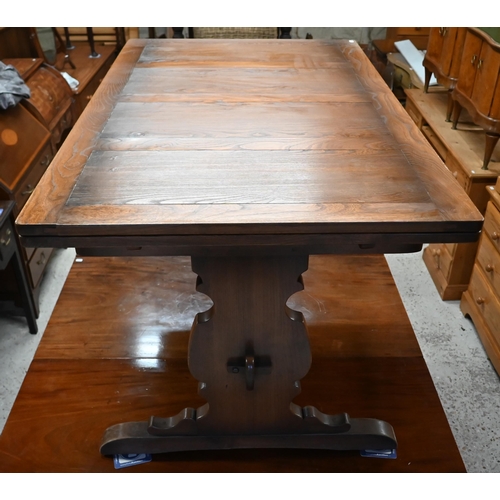 48 - An Ercol elm draw leaf dining table, on shaped trestle ends united by a mid-height centre stretcher,... 