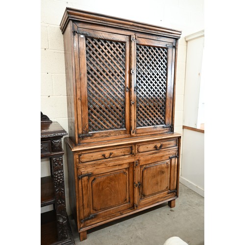 134 - An Indian hardwood two part cabinet with open lattice panelled doors on base with two drawers and pa... 