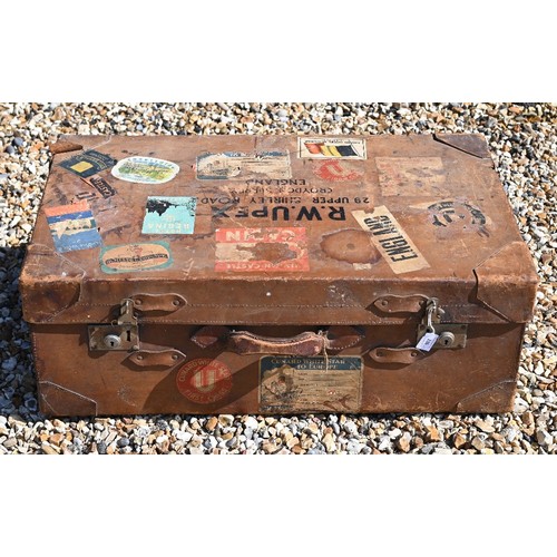 520 - A large vintage leather suitcase with various labels including Cunard White Star First Class and var... 