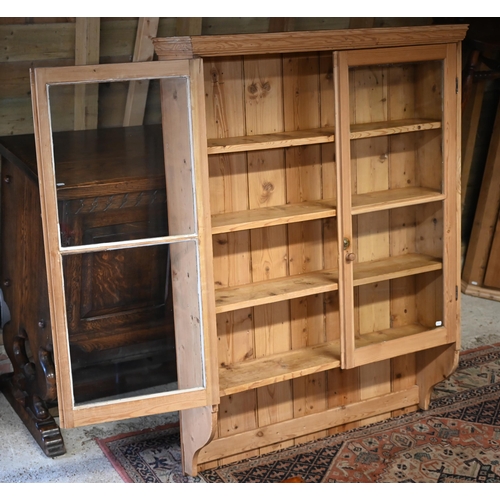 106 - A stripped pine twin glazed door hanging cabinet, 105 cm x 24 cm x 142 cm h o/all