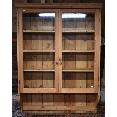 106 - A stripped pine twin glazed door hanging cabinet, 105 cm x 24 cm x 142 cm h o/all