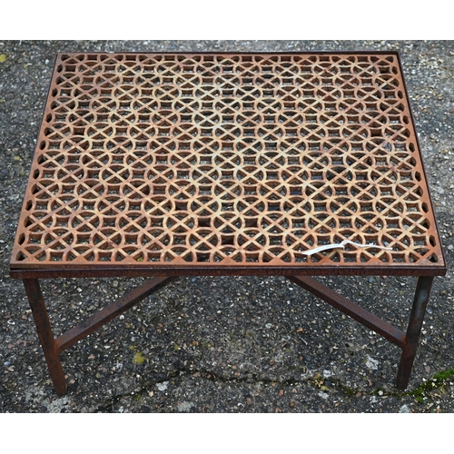 112 - A weathered cast iron 'grate' coffee table within a steel frame raised on cross stretchers to/w a pa... 