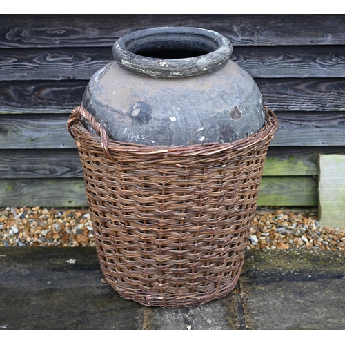 121 - A large fibreglass urn or olive jar in a tight-fitting wicker basket, 78 cm high