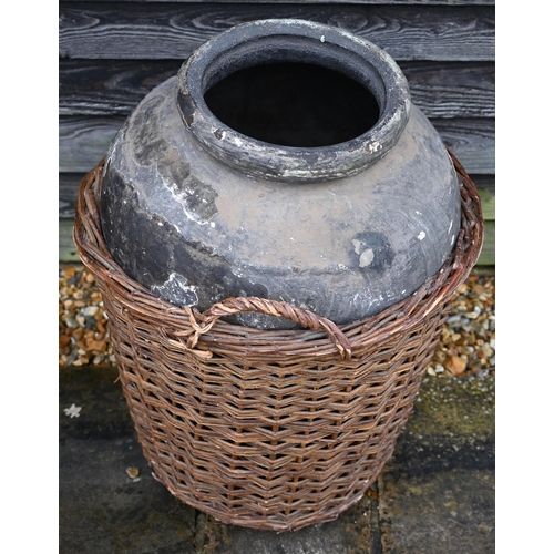 121 - A large fibreglass urn or olive jar in a tight-fitting wicker basket, 78 cm high